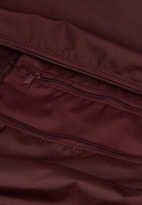 Bordeaux stoffen interieur met een zichtbare ritszak en een gladde textuur. Kenmerkt zich door een stijlvolle ritssluiting en een gevoerd ontwerp.