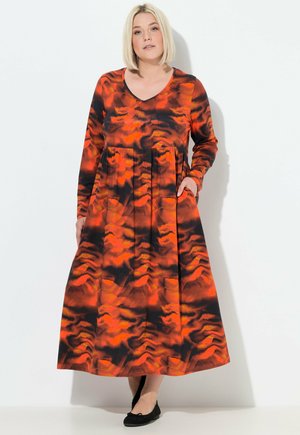 Langärmliges V-Ausschnitt-Kleid mit orange und schwarzem abstraktem Muster. Verfügt über einen entspannten Schnitt mit Taschen und einem fließenden Rock. Glatte Stoffoberfläche.