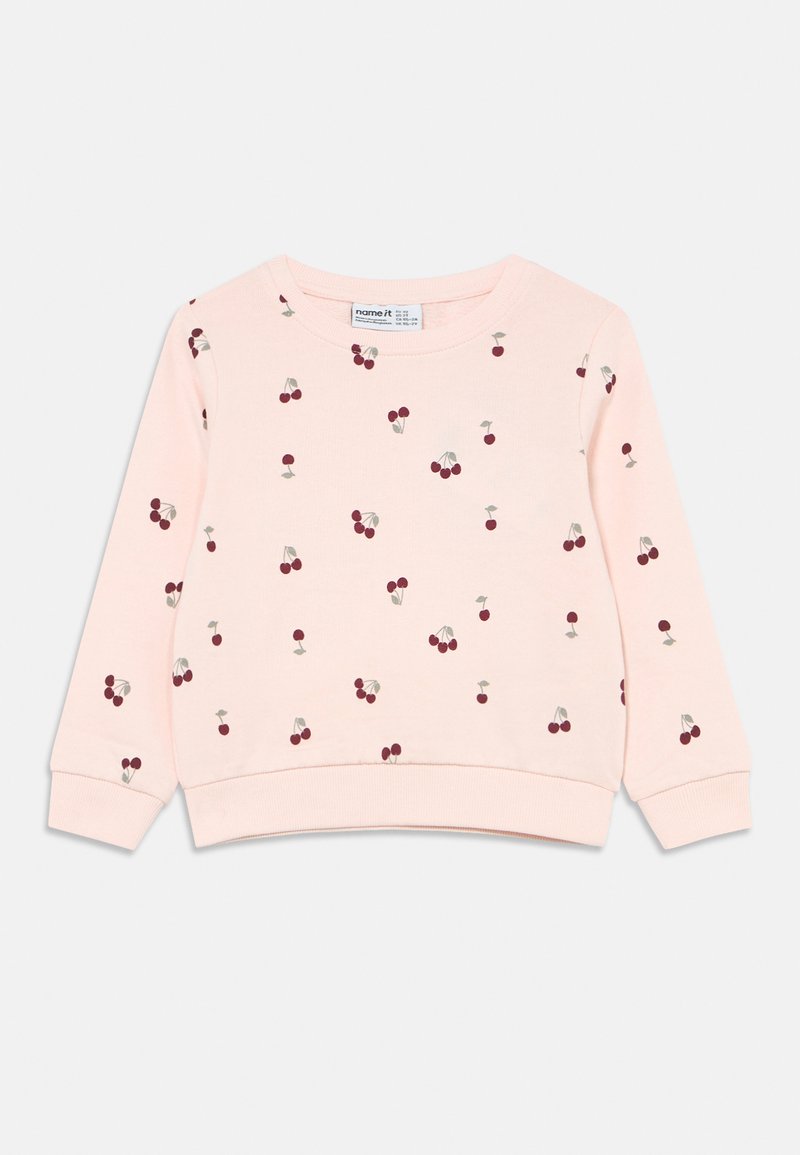 Różowa bluza z nadrukiem czerwonych wiśni. Posiada okrągły dekolt, długie rękawy oraz teksturowaną tkaninę. Dodatkowe detale to ściągacze na mankietach i u dołu bluzy.