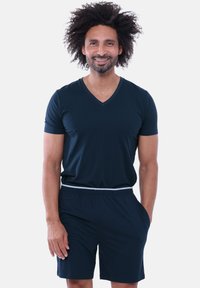 Marineblaues V-Ausschnitt-T-Shirt aus leichtem Stoff, kombiniert mit passenden Shorts. Die Shorts verfügen über einen elastischen Bund und seitliche Taschen.