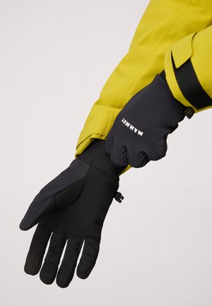 Black insulated gloves with a textured grip and adjustable wrist strap, worn alongside a bright yellow jacket. Features logo on wrist.