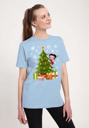 Lyseblå bomulds t-shirt med et tegneserie-juletræ, farverige gaver og en karakter, fremhævet af snefnug.