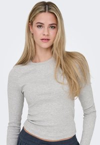 Μακρυμάνικη εφαρμοστή μπλούζα ανοιχτό γκρι με ραβδωτή υφή και στρογγυλή λαιμόκοψη, συνδυασμένη με σκούρα παντελόνια. Απλός και ευέλικτος σχεδιασμός.