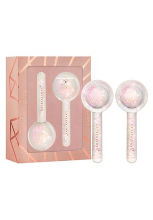 Cryo facial globes set in a rose gold geometric box. Globes are transparent with iridescent glitter, smooth texture, and rounded ends.