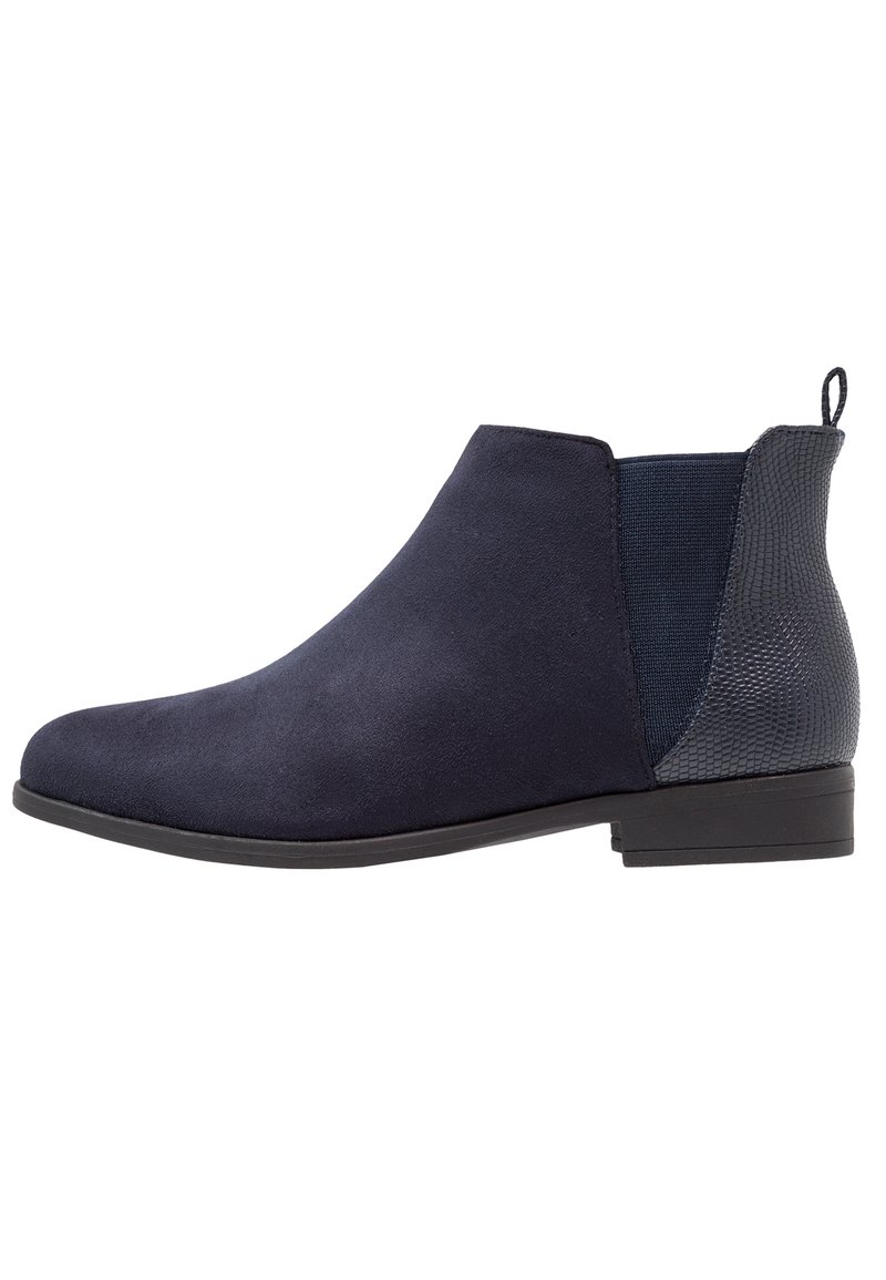 Stivaletti blu navy con una finitura in suede liscia, pannelli laterali elastici e un accento posteriore testurizzato. Suola piatta e design a punta tonda.