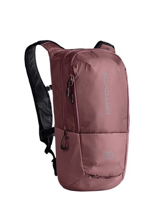 Kompakter staubig rosa Rucksack mit schwarzen gepolsterten Trägern, Reißverschlussfächern und ORTOVOX-Logo vorne.