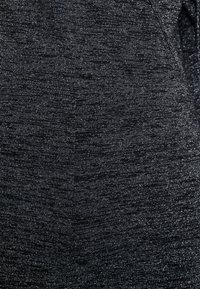 Tissu noir texturé avec des fils argentés chatoyants, présentant un motif mélangé subtil. Texture douce avec une finition lisse.