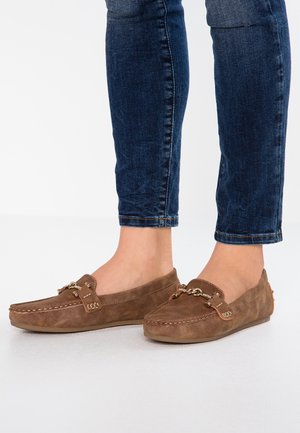 Brune ruskind loafers med guldkæde detalje båret med mørkeblå opkørte skinny jeans på bare fødder.