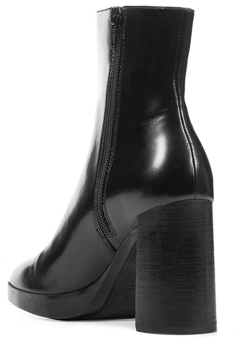 Botte de cheville en cuir noir avec un haut talon carré, fermeture éclair latérale et texture lisse. Caractérisée par un bout arrondi et un design minimaliste.