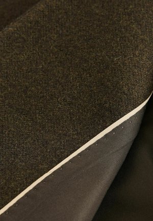 Two layers of fabric: a textured dark brown wool on top and a smooth dark material underneath, featuring a visible cream-colored edge.
