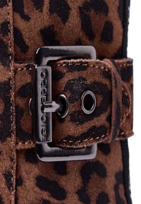 Cintura in suede a stampa leopardata con fibbia e dettagli in metallo nero. La cintura presenta dettagli di cucitura e una superficie testurizzata.