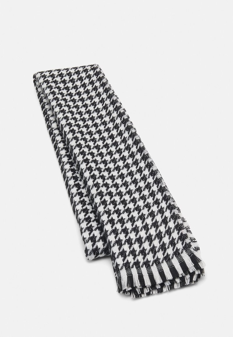 Écharpe à motif pied-de-poule noir et blanc, pliée avec des bords à franges, présentée sur un fond clair uni.