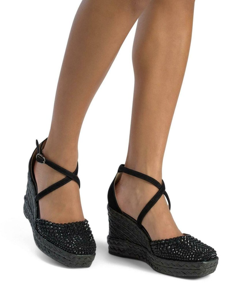 Scarpe con tacco a cuneo nere con una texture intrecciata e decorazioni di perline. Design con cinturini che presenta una chiusura alla caviglia con fibbia.
