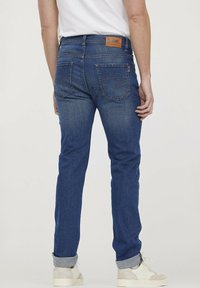 Blauwe denim jeans met een slim fit, met een lichte wassing, achterzakken, leren label op de tailleband en opgerolde boorden bij de enkels.