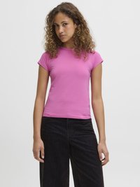Rosa kortermet t-skjorte med en tettsittende design, laget av et glatt, stretchy stoff. Kombinert med svarte vide bukser.