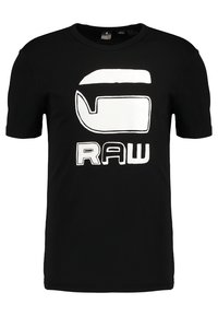 Černé bavlněné tričko s velkým bílým grafickým motivem na přední straně, na kterém je text "RAW" a abstraktní tvary. Klasický kulatý výstřih a krátké rukávy.