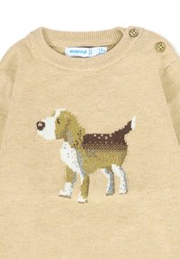 Beżowy sweter z dzianiny z grafiką beagle'a. Posiada okrągły dekolt i guziki na ramieniu. Wykonany z miękkiego materiału z teksturowanym wzorem.