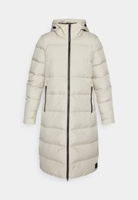 Ljusbeige puffjacka med huva, med en framzipper, två svarta dragkedjefickor på sidorna och quiltade sektioner för extra isolering.