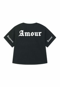 Melnas kokvilnas T-krekls ar īsām piedurknēm un brīvu piegriezumu. Aizmugurē un uz piedurknēm ir uzraksts "Amour" bālgā gotiskajā šriftā.