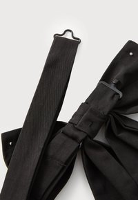 Black fabric straps with a smooth texture and glossy black hardware. Features a bow detail and snaps on both ends for attachment.