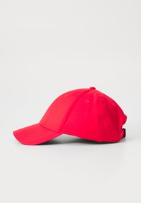 Casquette de baseball rouge avec une visière courbée, faite d'un tissu lisse, dotée de trous de ventilation et d'une sangle réglable à l'arrière.
