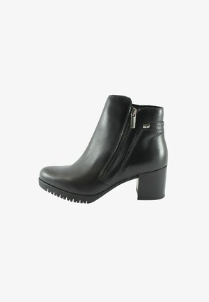 Bottine en cuir noir avec talon bloc, fermeture éclair latérale et semelle texturée, montrée de profil sur fond blanc.