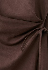 Material maro închis cu șnur legat, creând falduri adunate și textură.