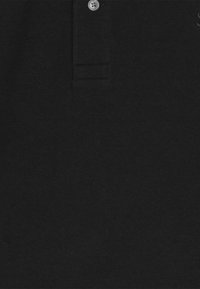 Zwarte poloshirt van textuurstof, met een twee-knopen herfst en een klein geborduurd logo aan de bovenlinkerkant.