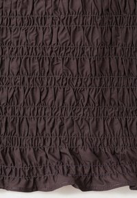 Tissu brun foncé avec des rangées horizontales de coutures élastiques rassemblées créant une texture froncée sur le matériau.