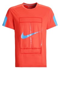 Röd idrottströja med blå ärmdetaljer, prydd med en stor blå Nike-logga i mitten och tillverkad av andningsbart Dri-FIT-material.