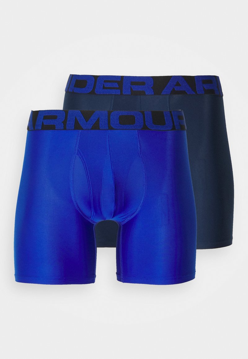Deux paires de boxers ajustés, l'une bleu vif et l'autre bleu foncé, avec des ceintures noires "Under Armour" ornées de lettres bleues.
