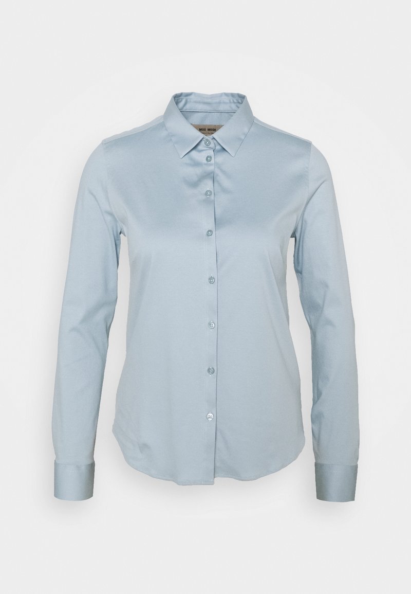 Chemise bleu clair à manches longues avec col et poignets, présentée sur un fond blanc uni.