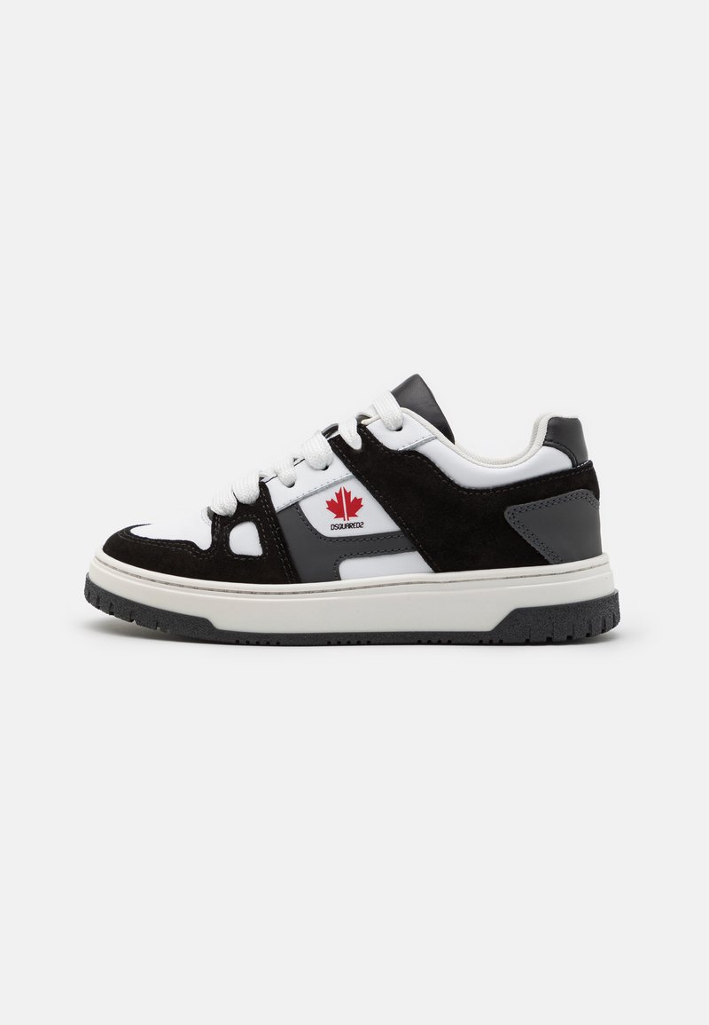Sneaker bianco e nero realizzato in materiali scamosciati e in pelle, con suola bianca, dettagli neri e un logo a foglia rossa di lato.