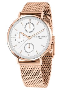 Rund vit urtavla med roséguldshänder och markeringar. Har tre små urtavlor för datum och veckodag, kompletterad med ett armband i roséguldsmask.