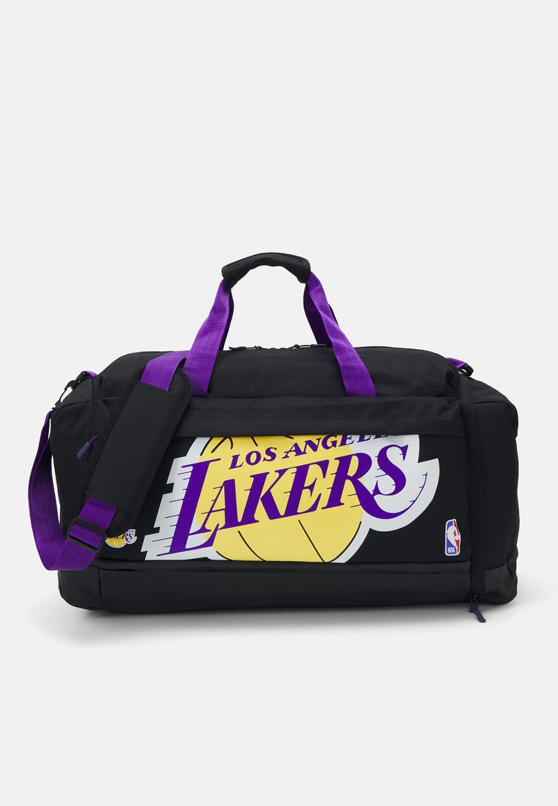 Čierna športová taška s fialovými uchami, s veľkým žltým a fialovým logom "Los Angeles Lakers" na prednej strane. Odolný materiál s uzávery na zips.
