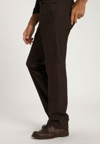 Bruna bomullsbyxor med rak ben-design, med framfickor och en mjuk textur, i kombination med mörkbruna snörskor.