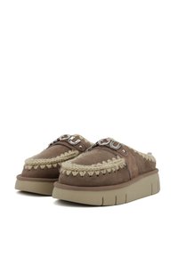 Scarpe slip-on in suede marrone con dettagli intrecciati, suola a piattaforma di altezza media color crema e particolari in metallo argentato.
