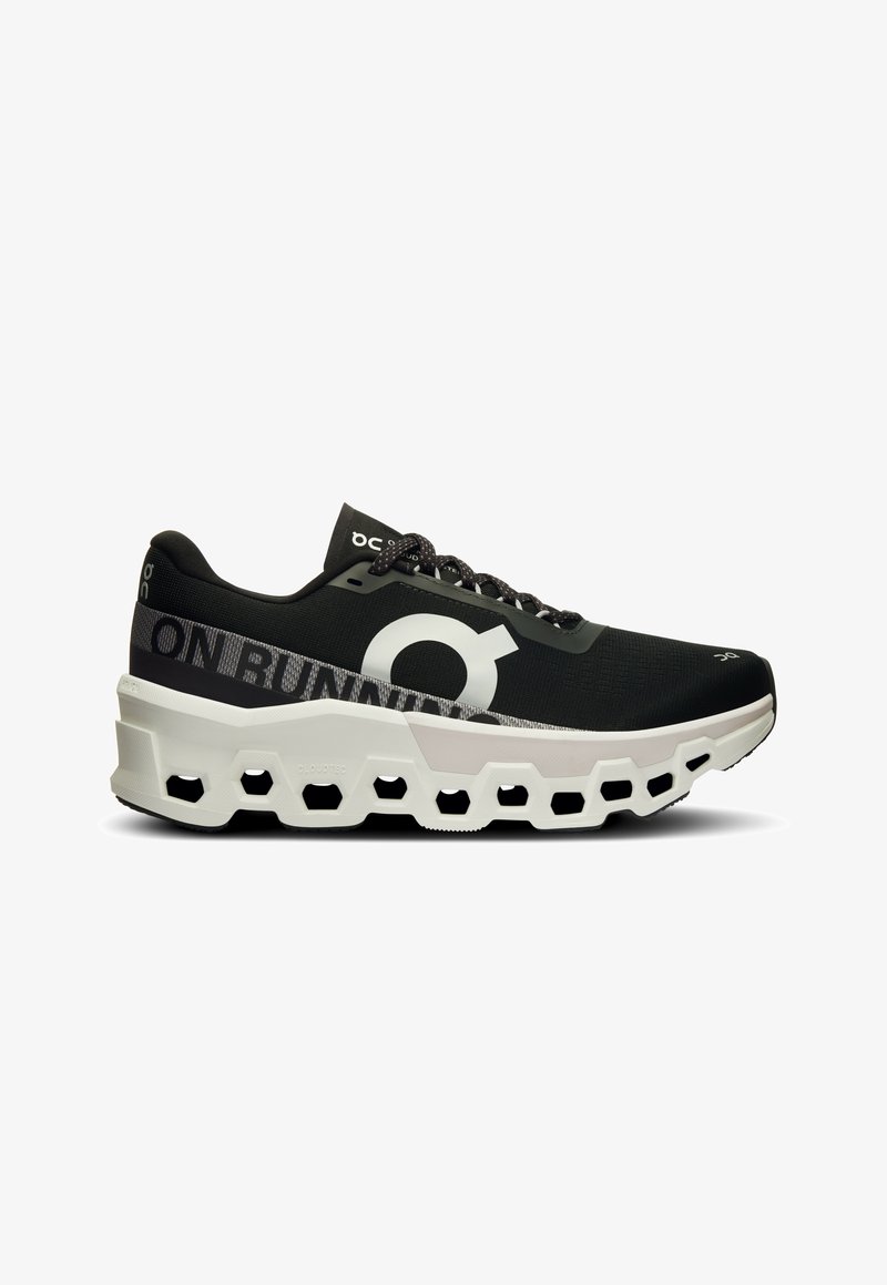 Zapatilla de running negra con parte superior de malla texturizada, logo blanco prominente y una suela moldeada única en blanco y negro con recortes hexagonales.