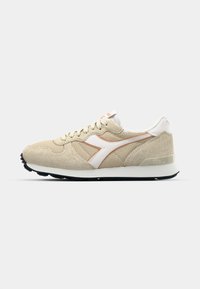 Beige suede sneaker with mesh panels, white accents, rounded toe, and black rubber sole. Features a lace-up closure and minimal branding.