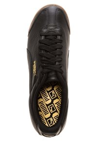 Svart läder Puma Roma-sneaker med svarta snören, gummisula och guld Puma-logga på sidan samt mönstrad innersula.