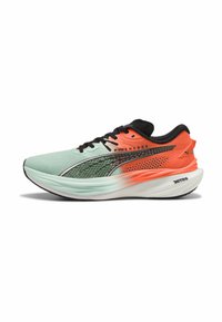 Zapatilla de running con parte superior de malla en verde claro y naranja, acentos negros, diseño texturizado y suela blanca acolchada con agarre.