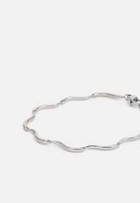 Silver metal bracelet featuring wavy links that alternate in shape, with a smooth, polished texture and a secure clasp.