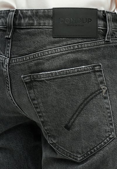 Čierne džínsy z denimu s textúrovaným povrchom, s veľkým zadným vreckom a čiernou koženou etikettou s embosovaným nápisom "DONDUF MADE IN ITALY".
