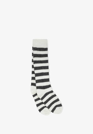 Gestreifte Socken mit einem gerippten Bündchen, aus einem weichen Material gefertigt. Farben sind Weiß und Dunkelgrau, mit horizontalen Streifen.