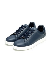 Sneaker in pelle blu navy con suole in gomma bianca, caratterizzati da punta rotonda, design con lacci e dettagli in metallo. Texture liscia su tutta la superficie.