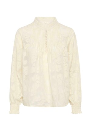 Kreemjas pika varrukaga pluus kõrge volangikraega, esikinnis nööpidega, õrn flores jakkardmustri ja elastsete varrukasäärtega.