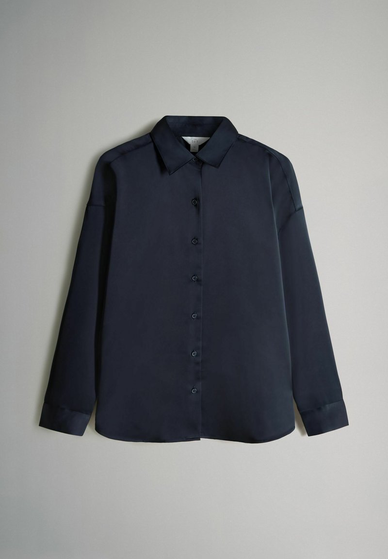 Completo coordinato da donna in due pezzi con camicia a maniche lunghe e pantaloni a gamba larga look casual primaverile 2026