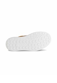 Schuhsohle mit einer weißen Gummibasis, die ein strukturiertes Muster aus kreisförmigen Griffen und ein geprägtes Logo in der Mitte aufweist.