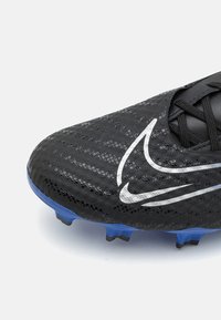 Scarpa da calcio nera con tomaia testurizzata, marchio bianco e tacchetti in gomma blu per la trazione. Progettata per le prestazioni su superfici in erba.