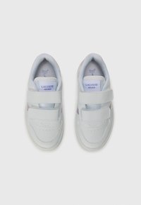 Baskets Lacoste blanches avec une tige en cuir lisse, des straps en velcro et des accents subtils de rose. Bout arrondi avec des perforations.